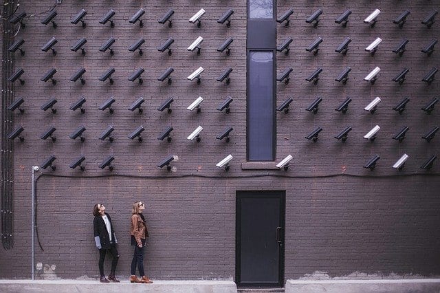 people looking up at many surveillance cameras