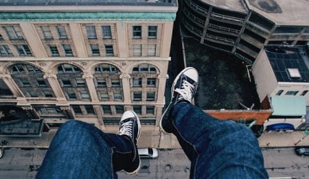feet hanging off edge of building