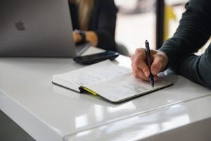 man taking notes in meeting